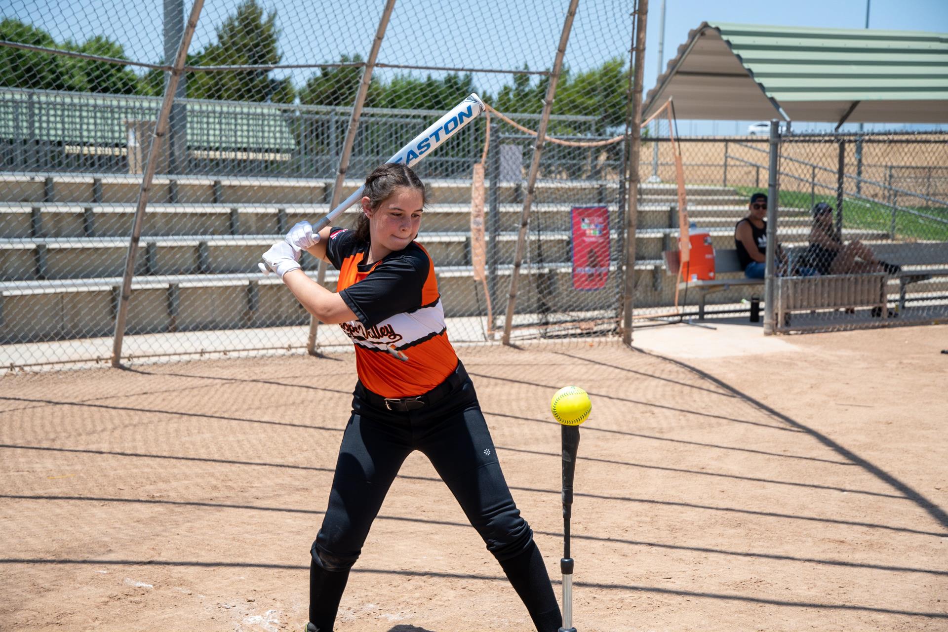 young girl lines up to swing during softball