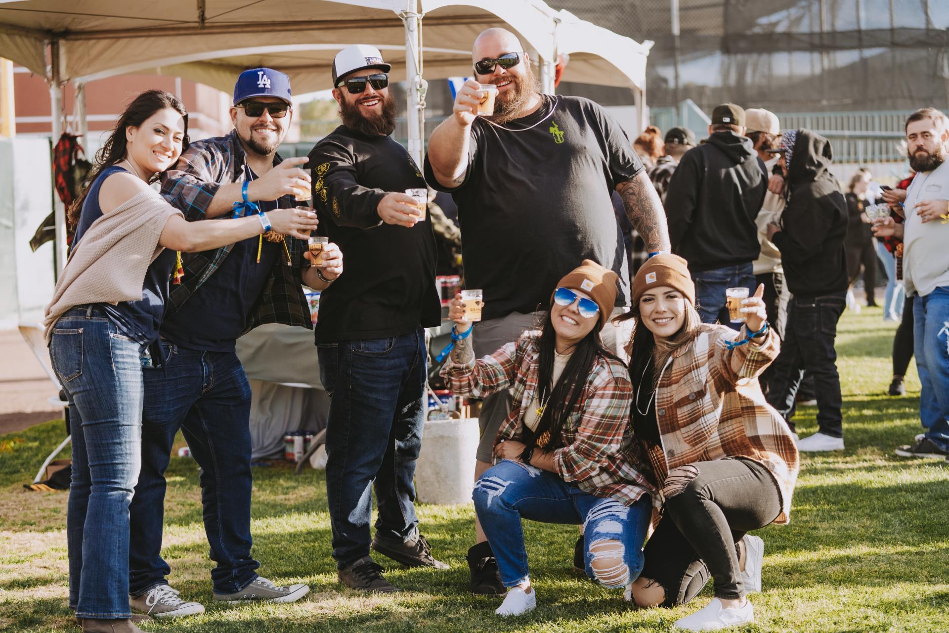 beer enthusiasts pose with big smiles and full tasting glasses