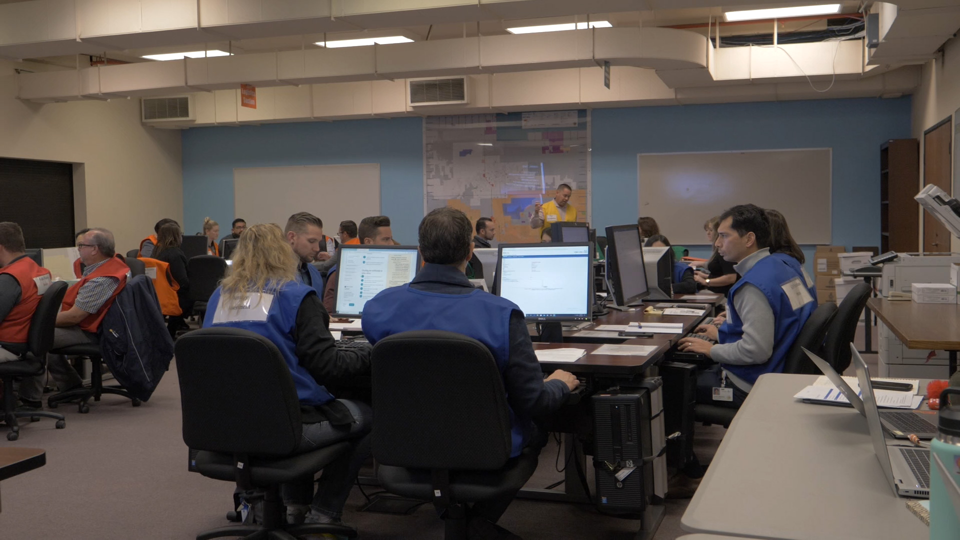 city staff are shown working in the emergency operations center at city hall