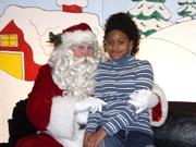 Girl posing on Santa's lap.